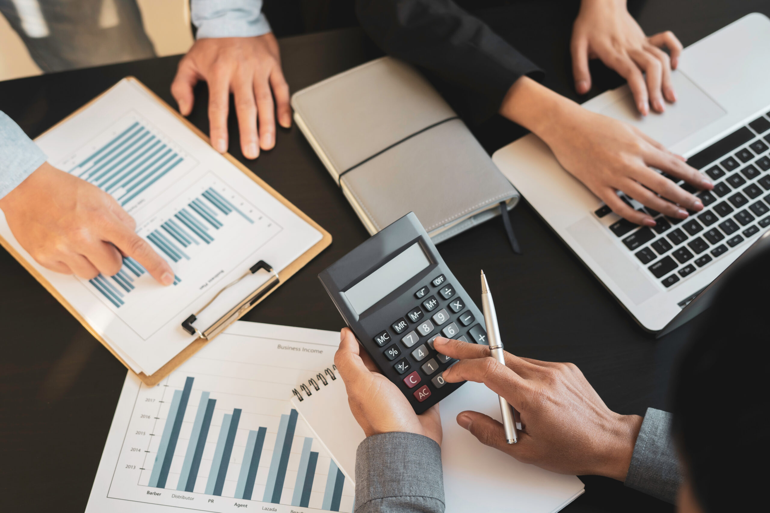 accounting salon with people working in documents, calculator and laptop