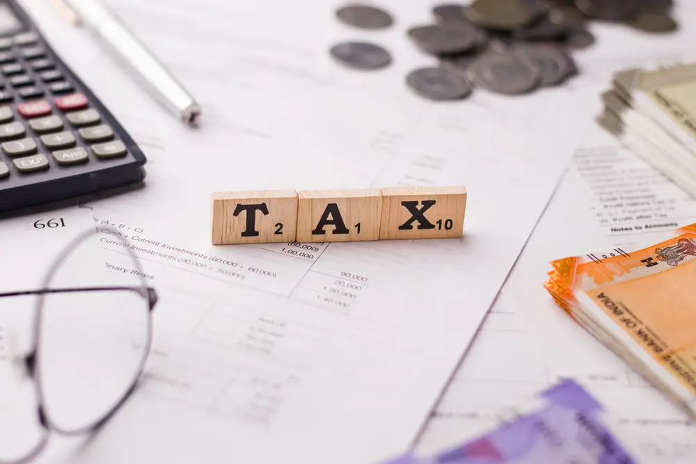 taxation services with papers, eyeglass, coins and calculator. Tax deductions
